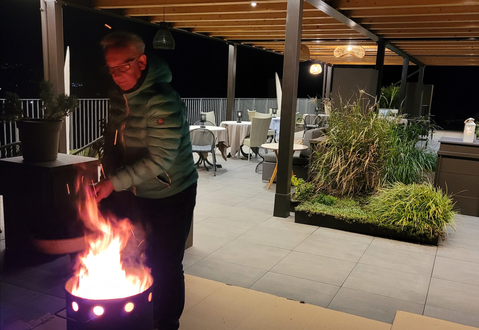 Törggelen - Terrasse mit Mann vor einem Feuer brät Kastanien - Matill